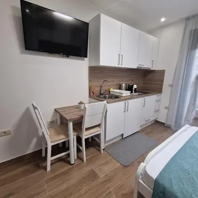 a small kitchen with a table and a sink at Apartments NIKOS FAMILY in Ulcinj