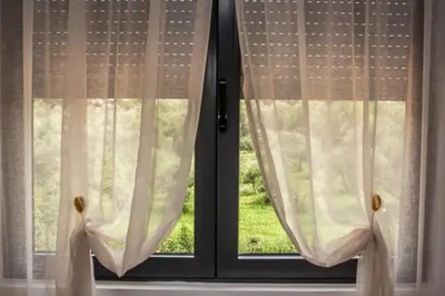 a window with white curtains in a room at Apartments NIKOS FAMILY in Ulcinj