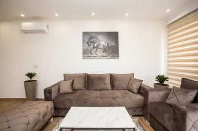 a living room with a couch and a horse picture on the wall at Apartments NIKOS FAMILY in Ulcinj