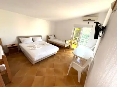 a bedroom with a white bed and a chair at ADO Apartmani Ulcinj Velika Plaza Donji Stoj in Donji Štoj