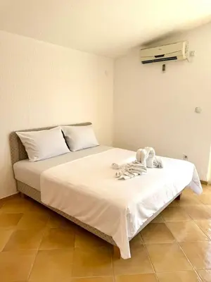 a bedroom with a bed with towels on it at ADO Apartmani Ulcinj Velika Plaza Donji Stoj in Donji Štoj