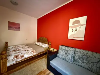 a bedroom with a bed and a couch in it at City Center Cozy Studio in Podgorica