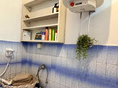 a bathroom with a blue tiled wall with a cabinet at City Center Cozy Studio in Podgorica
