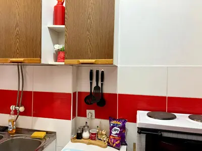 a kitchen with red and white tiles on the wall at City Center Cozy Studio in Podgorica