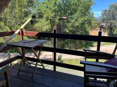a wooden table and a chair on a porch at Velicanka hostel in Ulcinj