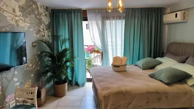 a bedroom with a large bed with green curtains at Center Blue & Green in Budva