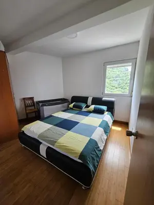 a bedroom with a bed in a room with a window at Panorama Milocer Apartments in Budva