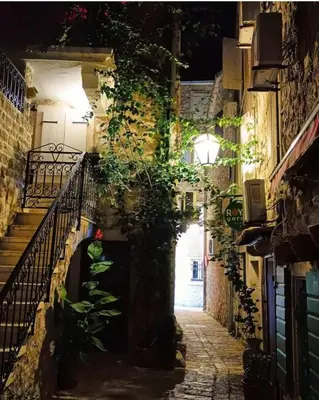 an alley in an old town at night at Panorama Milocer Apartments in Budva