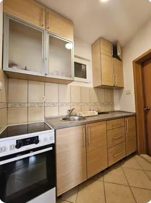a kitchen with wooden cabinets and a sink and a stove at Panorama Milocer Apartments in Budva