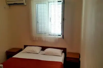 a small bedroom with a bed with a window at Guest house Rade Z in Budva