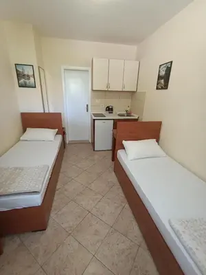 a small room with two beds and a kitchen at Guest house Rade Z in Budva