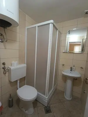 a bathroom with a shower and a toilet and a sink at Guest house Rade Z in Budva