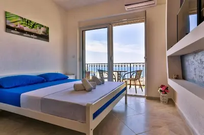 a bedroom with a bed and a balcony at MarBok Apartments with SeaView in Utjeha
