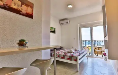 a living room with a table and a balcony at MarBok Apartments with SeaView in Utjeha