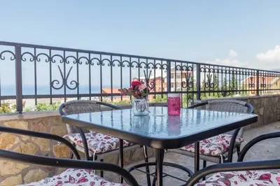 a table with a vase of flowers on a balcony at MarBok Apartments with SeaView in Utjeha