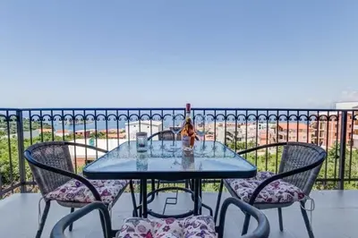 a table with three chairs and a candle on a balcony at MarBok Apartments with SeaView in Utjeha