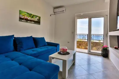 a living room with a blue couch and a table at MarBok Apartments with SeaView in Utjeha