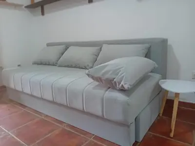 a couch with pillows on it in a room at Mota saste lux in Sveti Stefan