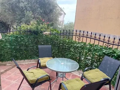 a patio with a table and chairs and a fence at Mota saste lux in Sveti Stefan