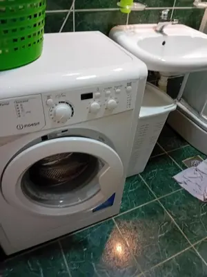 a white washing machine sitting next to a sink at Mota saste lux in Sveti Stefan