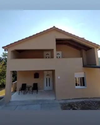 a house with two chairs and a table at Apartmani Suvodoli in Rvaši