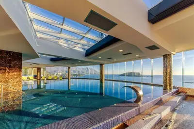 an indoor swimming pool with a view of the water at Luxury 3 bedroom flat in Tre canne hotel next to the beach in Budva