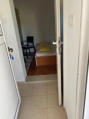 a hallway with a room with a bed and a chair at Апартаменты in Sutomore