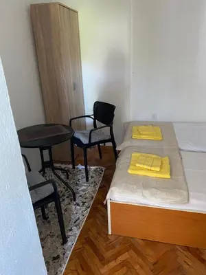 a room with two beds and a table and chairs at Апартаменты in Sutomore