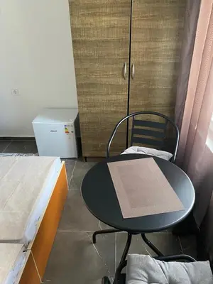 a table and chair in a room with two beds at Апартаменты in Sutomore