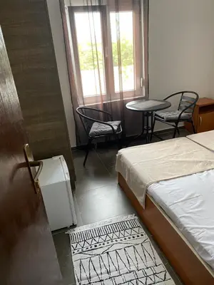 a bedroom with a bed and two chairs and a table at Апартаменты in Sutomore