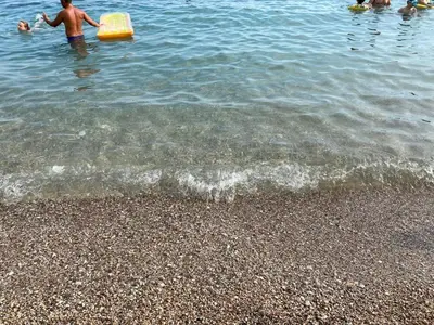 a group of people in the water at the beach at Апартаменты in Sutomore