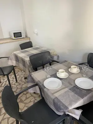 a dining room with two tables and chairs and a microwave at Апартаменты in Sutomore