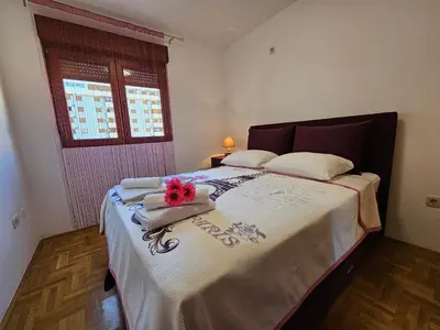 a bedroom with a bed with flowers on it at Luča apartman in Podgorica