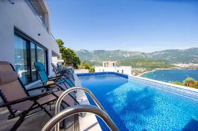 a balcony with chairs and a swimming pool at Villa Maya in Budva