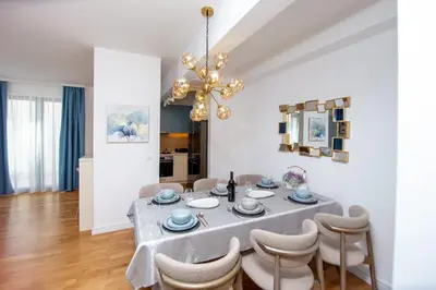 a dining room with a table with chairs and a chandelier at Villa Maya in Budva