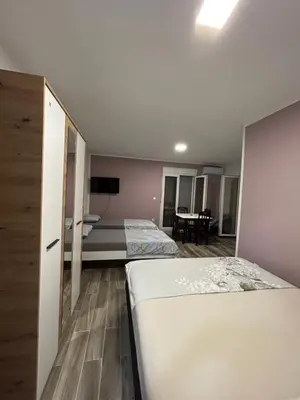 a hotel room with two beds and a table at NNL Apartments in Sutomore