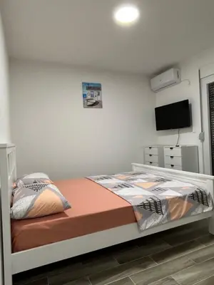 a bedroom with a bed and a flat screen tv at NNL Apartments in Sutomore