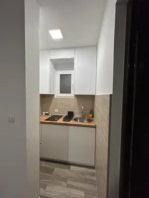 a small kitchen with white cabinets and a sink at NNL Apartments in Sutomore