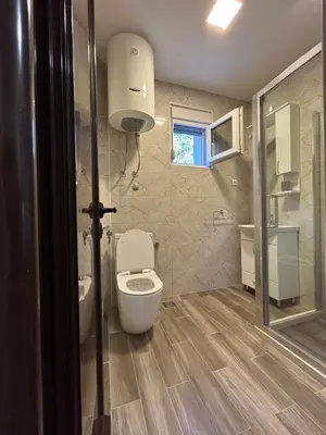 a bathroom with a white toilet and a sink at NNL Apartments in Sutomore