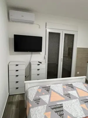 a bedroom with a bed and a flat screen tv at NNL Apartments in Sutomore