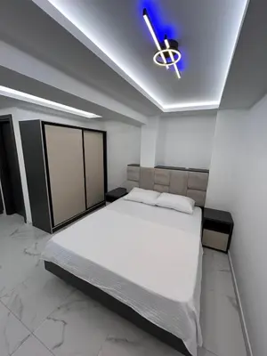 a bedroom with a large white bed and a ceiling at Merlin Prestige Apartments in Budva