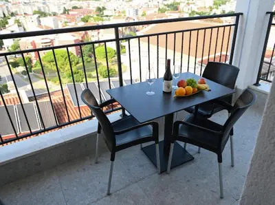 a table with a bottle of wine and fruit on a balcony at Merlin Prestige Apartments in Budva