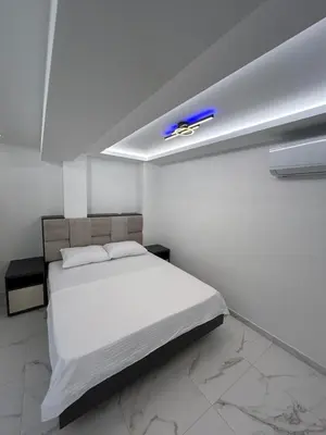 a bedroom with a white bed with a blue car on the ceiling at Merlin Prestige Apartments in Budva