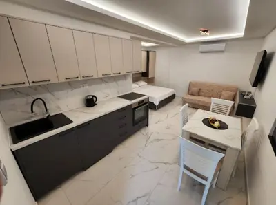 a kitchen and living room with a couch and a table at Merlin Prestige Apartments in Budva