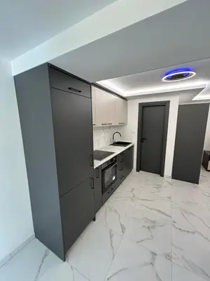 a kitchen with white marble floors and a blue light at Merlin Prestige Apartments in Budva