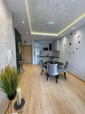 a living room with a table and chairs and a clock at Old barkery, the most exclusive complex in Budva in Budva