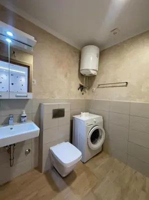 a bathroom with a toilet and a sink and a washing machine at Old barkery, the most exclusive complex in Budva in Budva