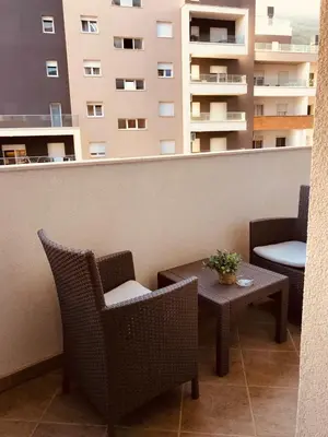 a balcony with chairs and a table and a building at Old barkery, the most exclusive complex in Budva in Budva