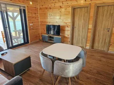 a living room with a table and chairs and a television at Estuary Cottage Ada Bojana in Ulcinj