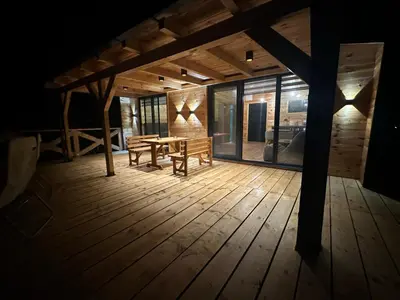 a wooden deck with a wooden table and benches at Estuary Cottage Ada Bojana in Ulcinj